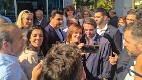 El expresidente Aznar, este viernes, sonriente, posando para un selfie con una militante del PP, en la puerta del salón de celebraciones Acuario de Torre Pacheco.