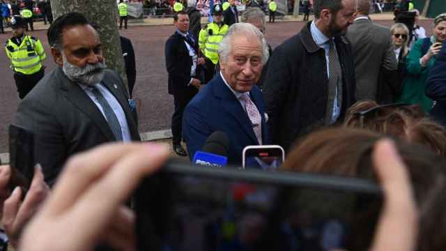El rey Carlos III (C) de Gran Bretaña saluda a los simpatizantes a lo largo del Mall en Londres, Gran Bretaña, el 5 de mayo de 2023.