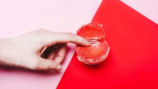 Detalle de una mano, abriendo una fruta.