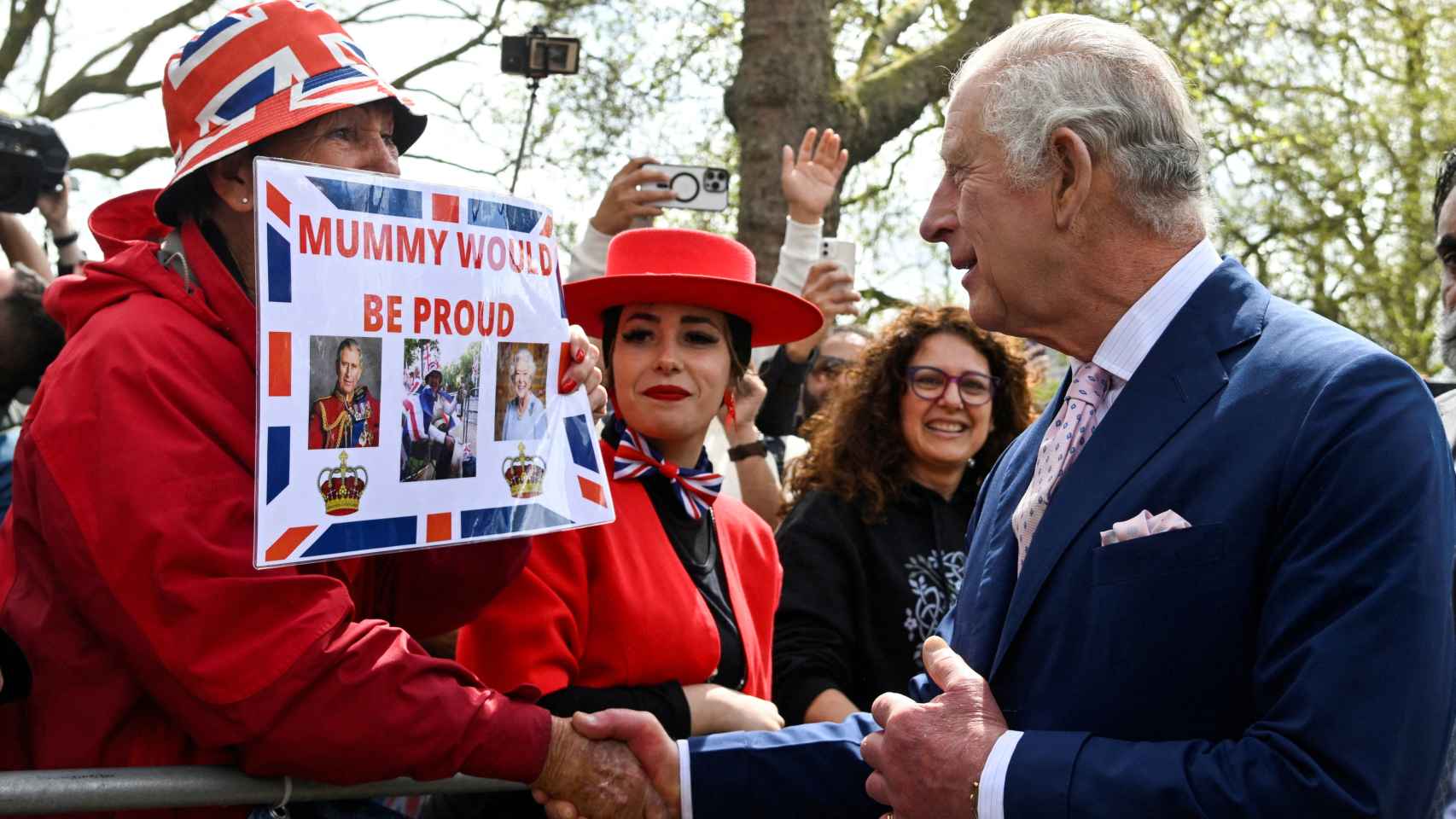 Carlos III saluda a unos ciudadanos, a las puertas del Palacio de Buckingham.