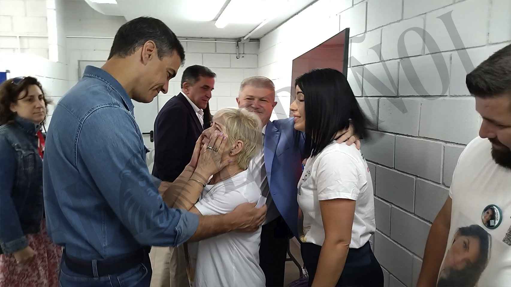 Felisa echándose las manos a la cara para no romper a llorar, mientras Pedro Sánchez la consuela.