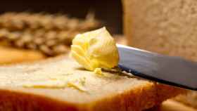 Una persona extiende un poco de mantequilla sobre una rebanada de pan.