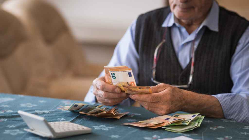 Un pensionista cuenta su dinero en efectivo.