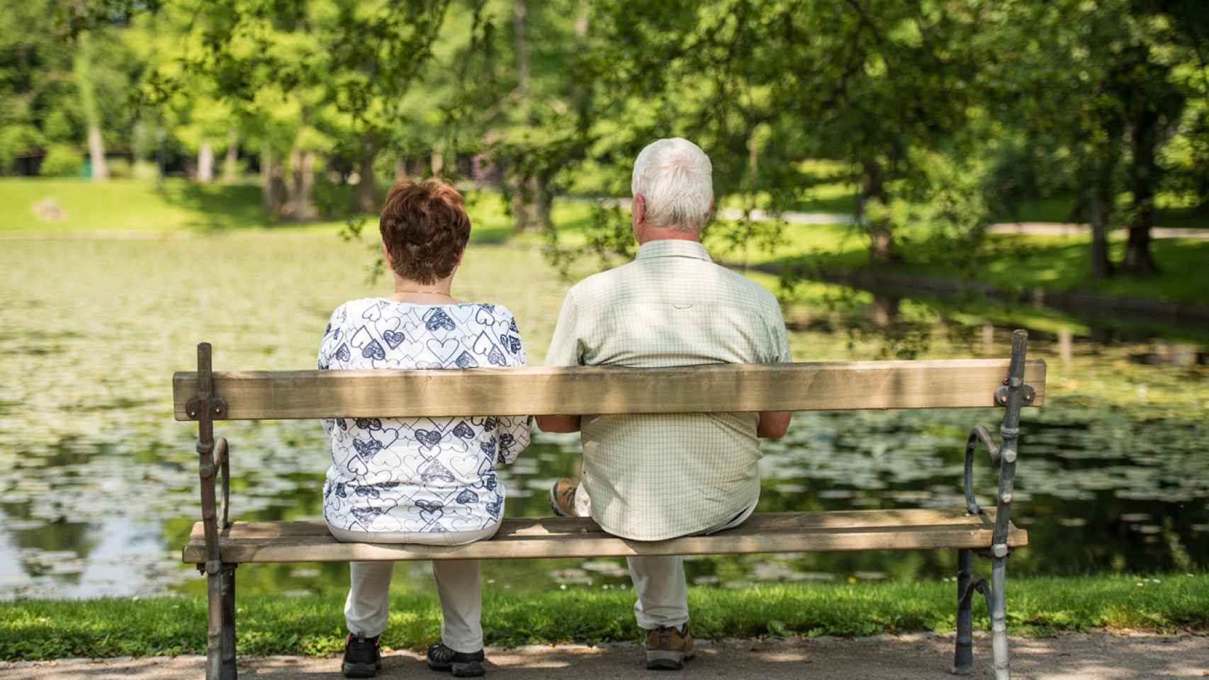Dos personas mayores sentadas en un banco.