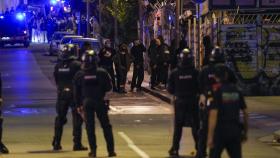 Mossos d'Esquadra vigilan a varios okupas de los edificios de La Ruïna y el Kubo en la plaza Bonanova de Barcelona.