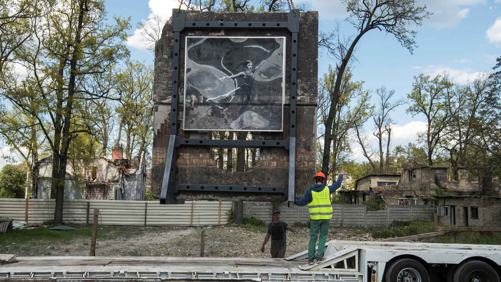 Los trabajadores llevan en un camión una parte de una pared con el trabajo del artista Banksy, en las afueras de Kiev.