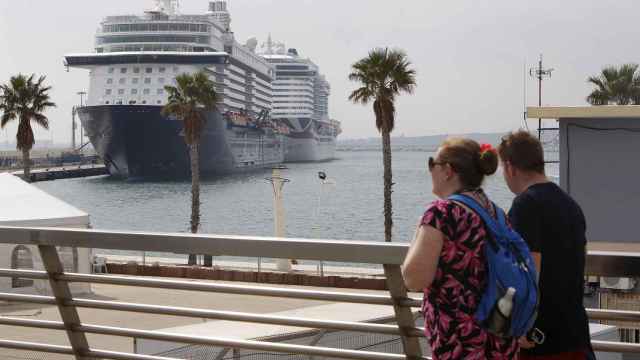 Varios turistas en Alicante, con un crucero al fondo, en imagen de archivo.