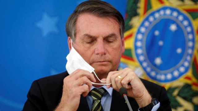 Bolsonaro se coloca la mascarilla durante una rueda de prensa, en 2020.