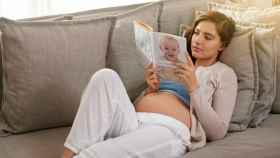 Mujer embarazada leyendo.