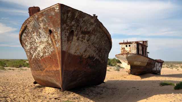 Dos barcos oxidados en medio de un mar de Aral seco.