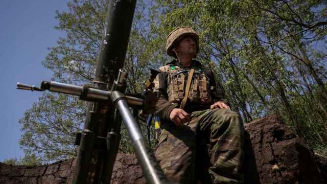 Un miembro del servicio ucraniano se prepara para disparar un mortero en una línea del frente.