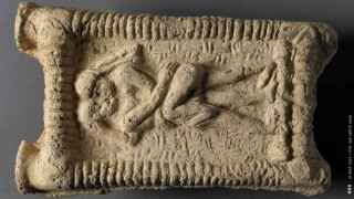 Modelo de arcilla babilónico del año 1800 a.C. que muestra a una pareja desnuda en un sofá besándose.