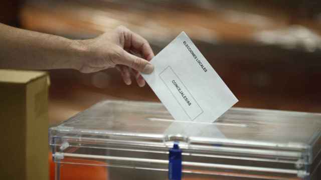 Un hombre deposita su voto en la urna en las elecciones municipales.