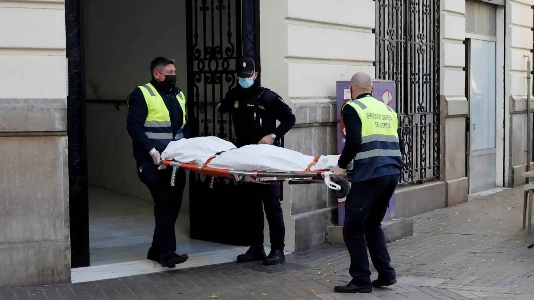 Operarios del retén fúnebre sacan el cadáver de Cristina, de 30 años de edad.
