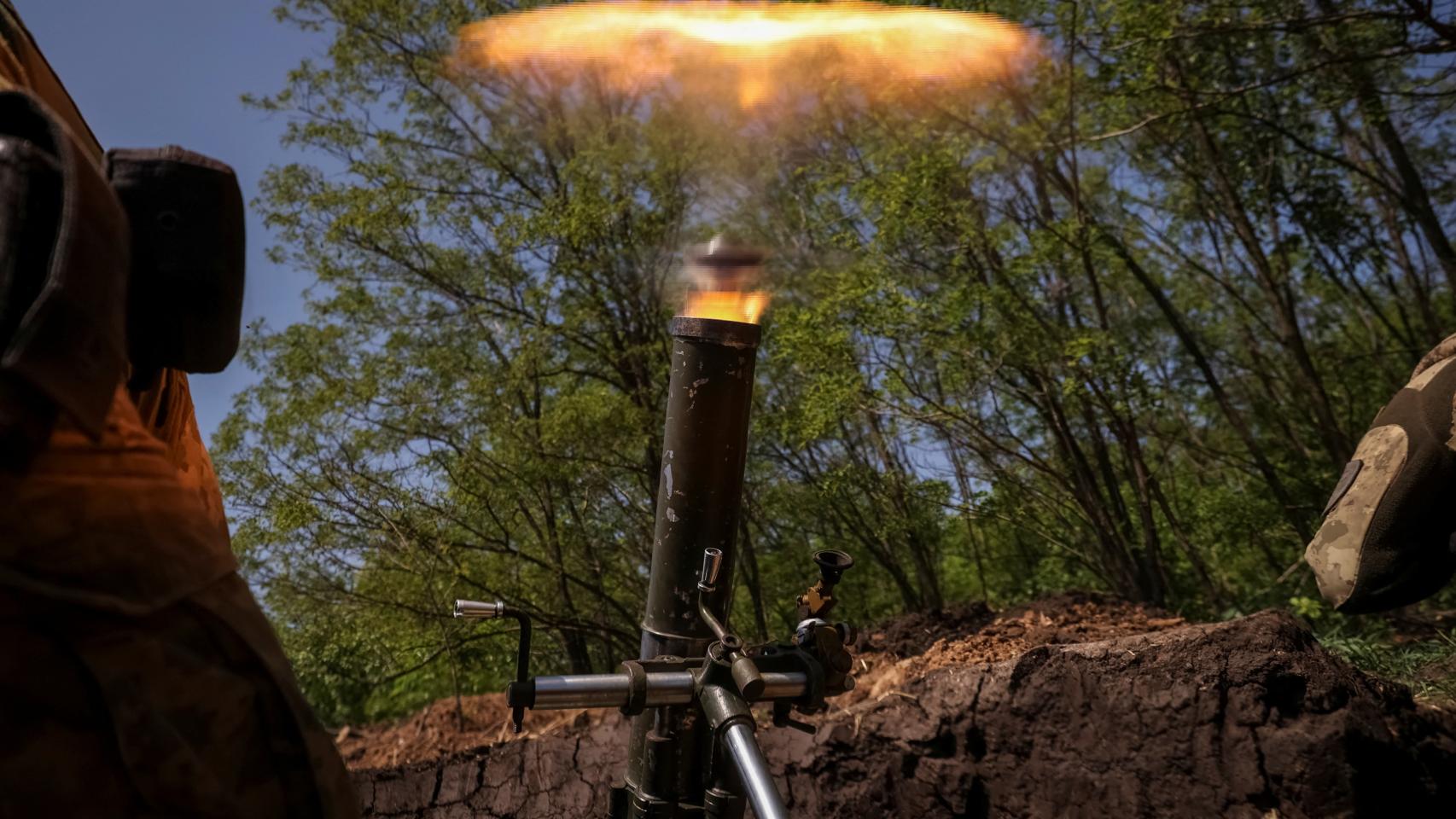 Ukrainian service members fire a mortar at a front line near the town of Bakhmut.