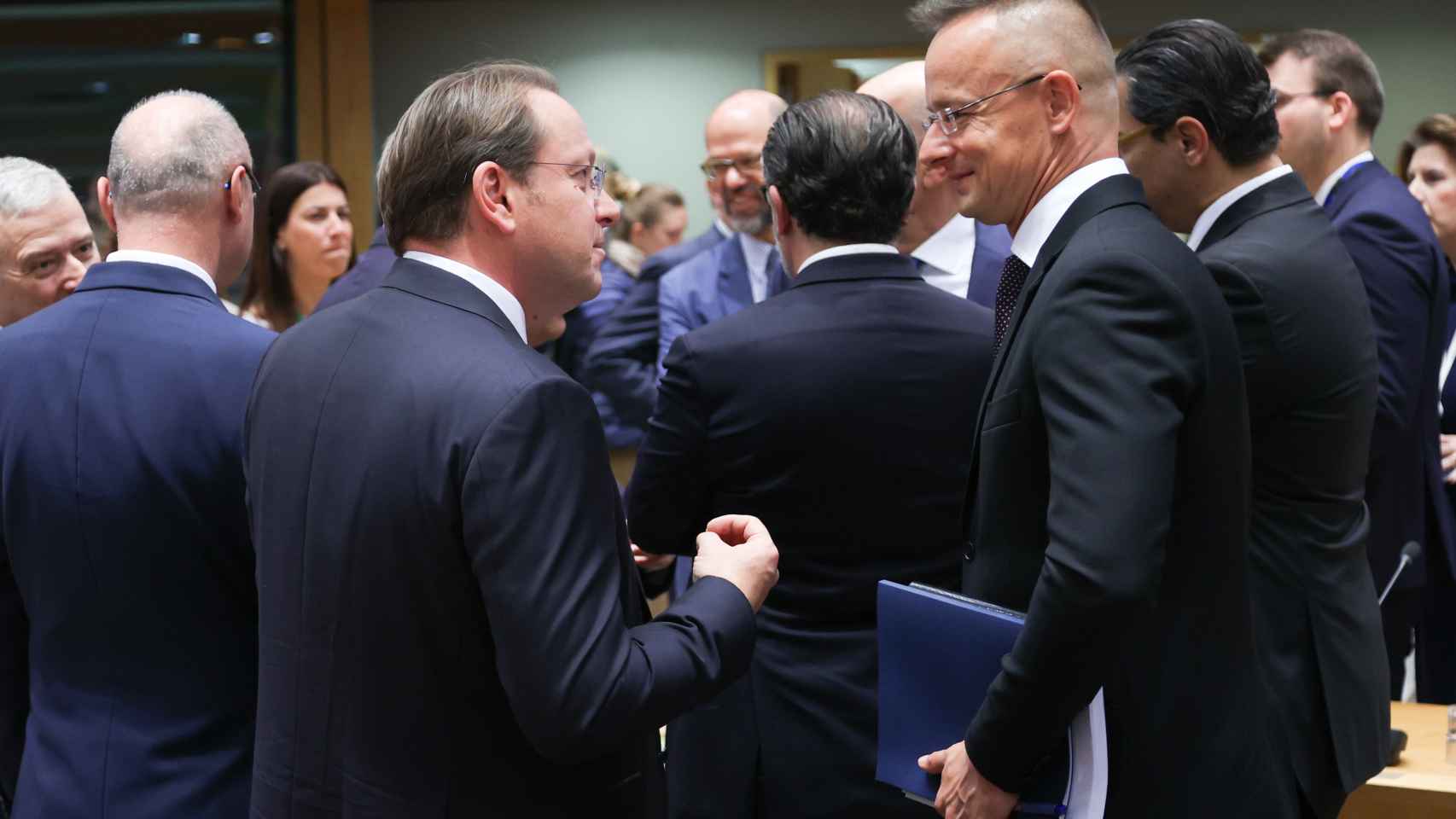 El ministro de Exteriores de Hungría, Péter Szijjártó (a la derecha de la imagen), conversa con el comisario de Ampliación durante la reunión de este lunes en Bruselas
