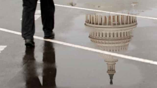 La cúpula del Capitolio de Estados Unidos se refleja en un charco de agua en Washington.