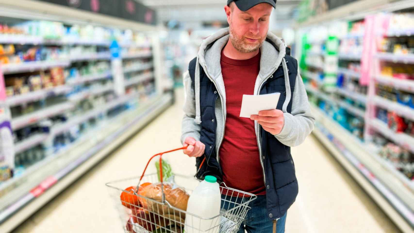 Un hombre preocupado haciendo la compra en el supermercado.