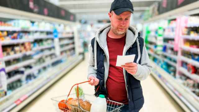 Un hombre preocupado haciendo la compra en el supermercado.