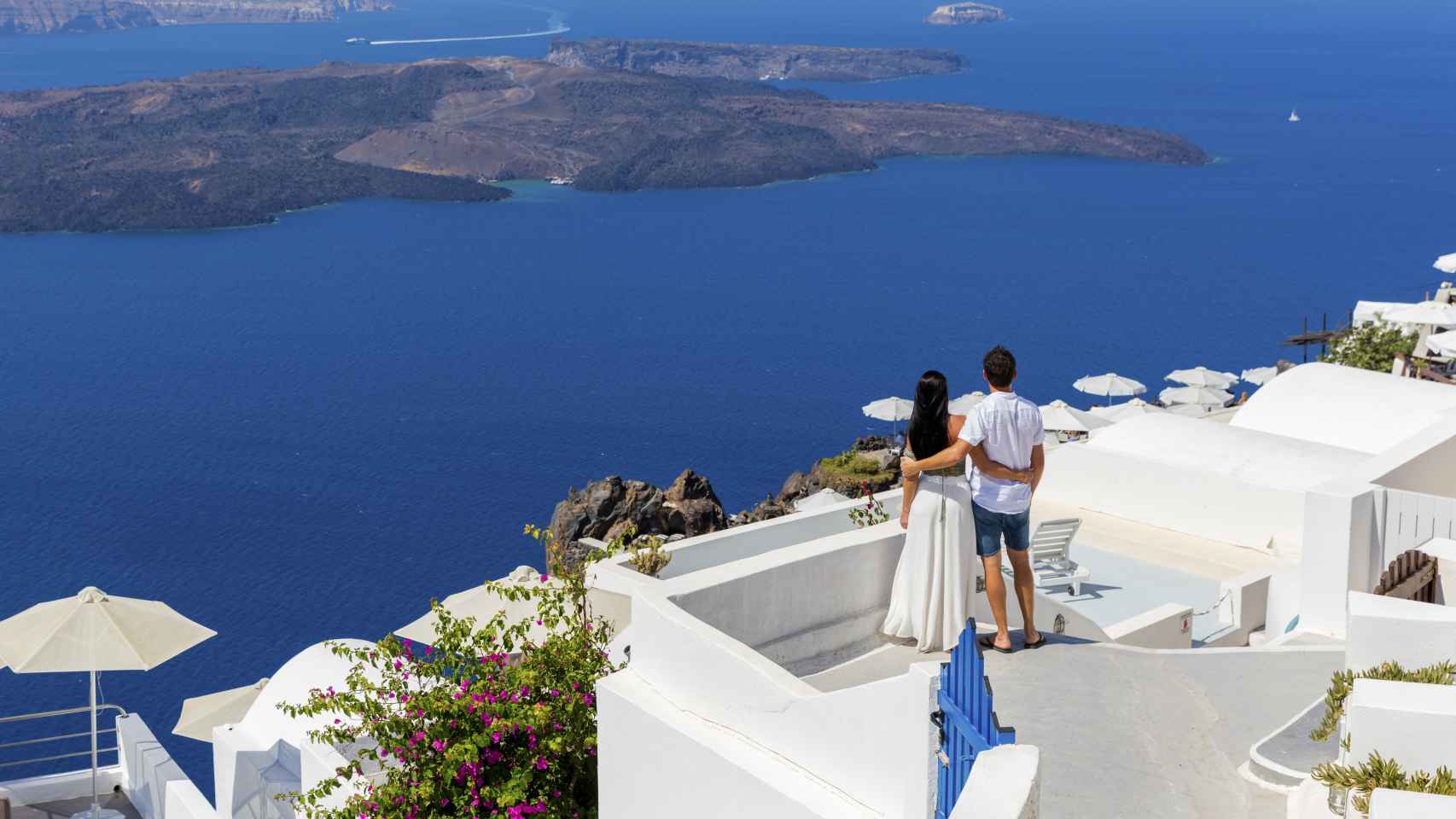 Una pareja joven disfruta de las vistas desde una villa en Santorini.
