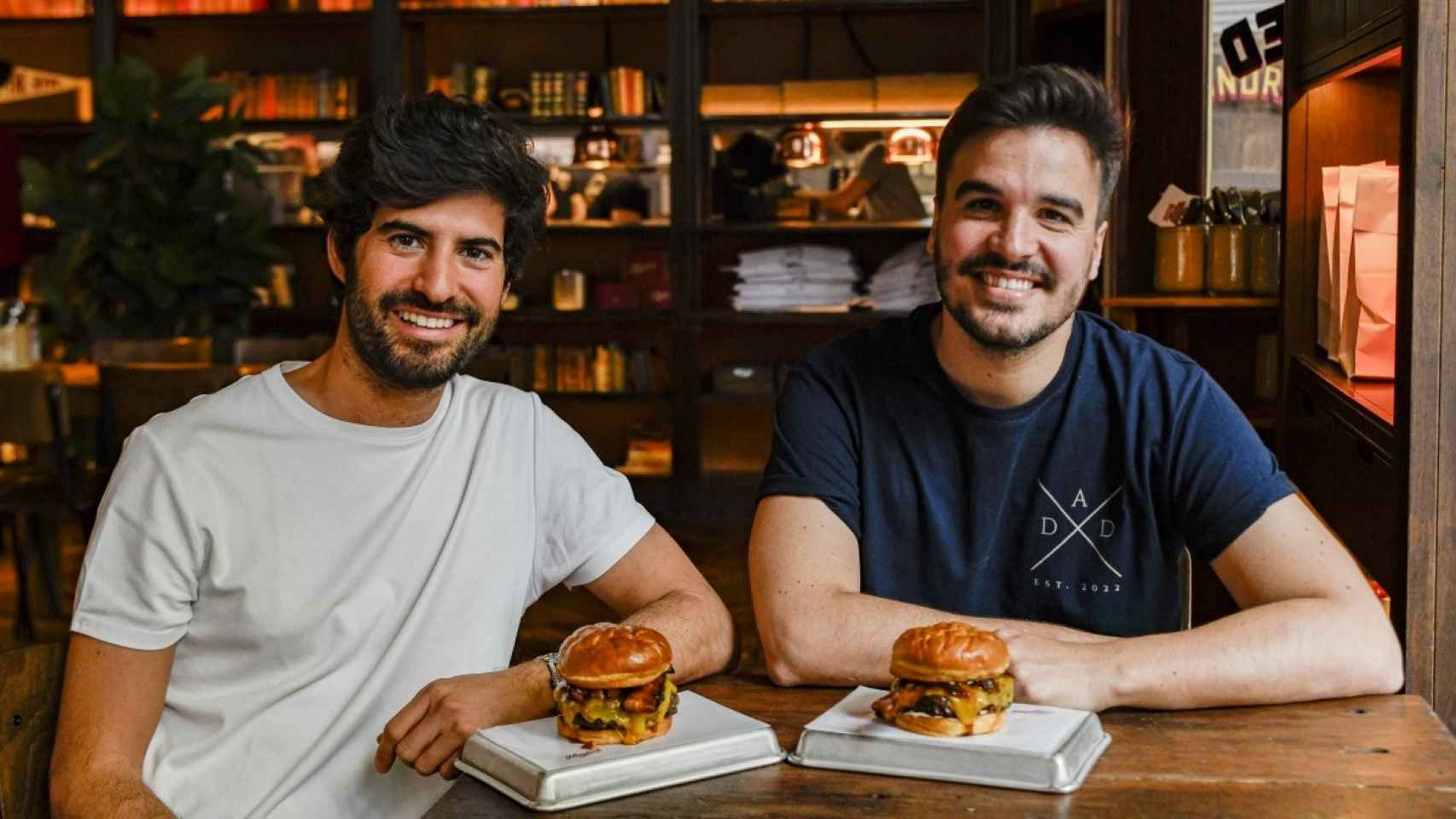 Ezequiel y Alex con dos de sus hamburguesas más conocidas.