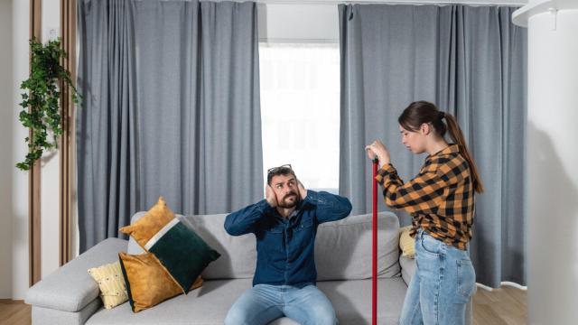 Pareja joven soportando los decibelios de la fiesta de un vecino.