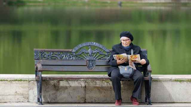 Una anciana leyendo en el parque.