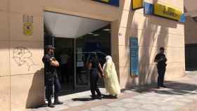 Dos ciudadanas de Melilla entran en una oficina de Correos custodiada por la Policía Nacional.