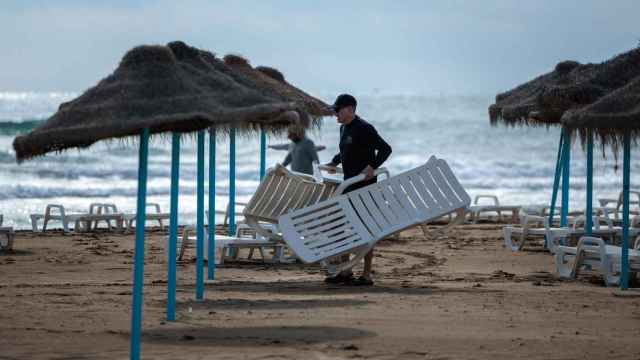 Un hombre colocando hamacas en una playa valenciana, hace unas semanas.