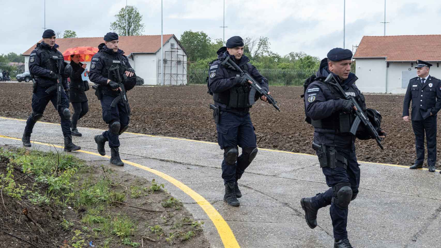 Oficiales de policía armados caminan frente a los almacenes donde se entregaron las armas a la policía en los primeros diez días de la amnistía de armas después de los tiroteos masivos en el país, cerca de Smederevo, Serbia, el 14 de mayo de 2023.