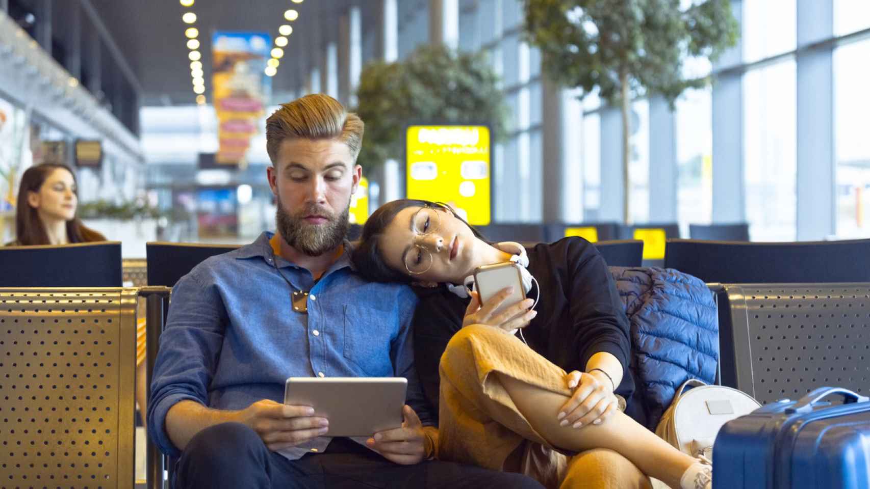 Una pareja esperando en el aeropuerto porque su vuelo se retrasa.