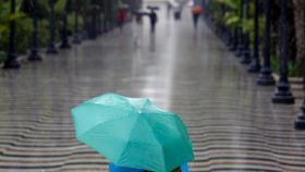 Una persona con un paraguas en la Explanada de España, en Alicante, esta semana.