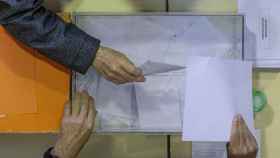 Una persona deposita un voto en una urna en la comunidad Valenciana, este domingo.