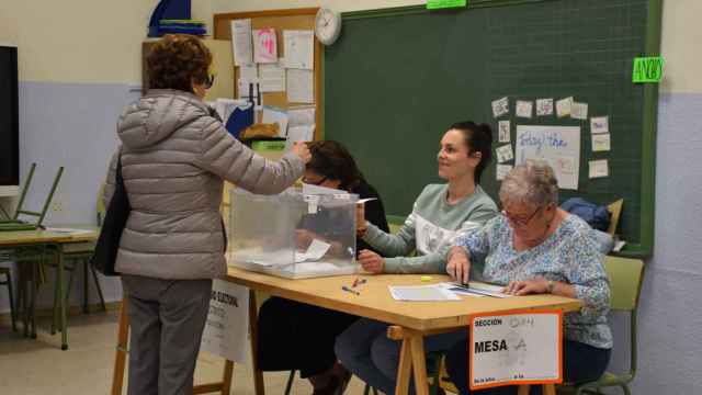 Una mujer deposita el voto en un colegio electoral de Valladolid.