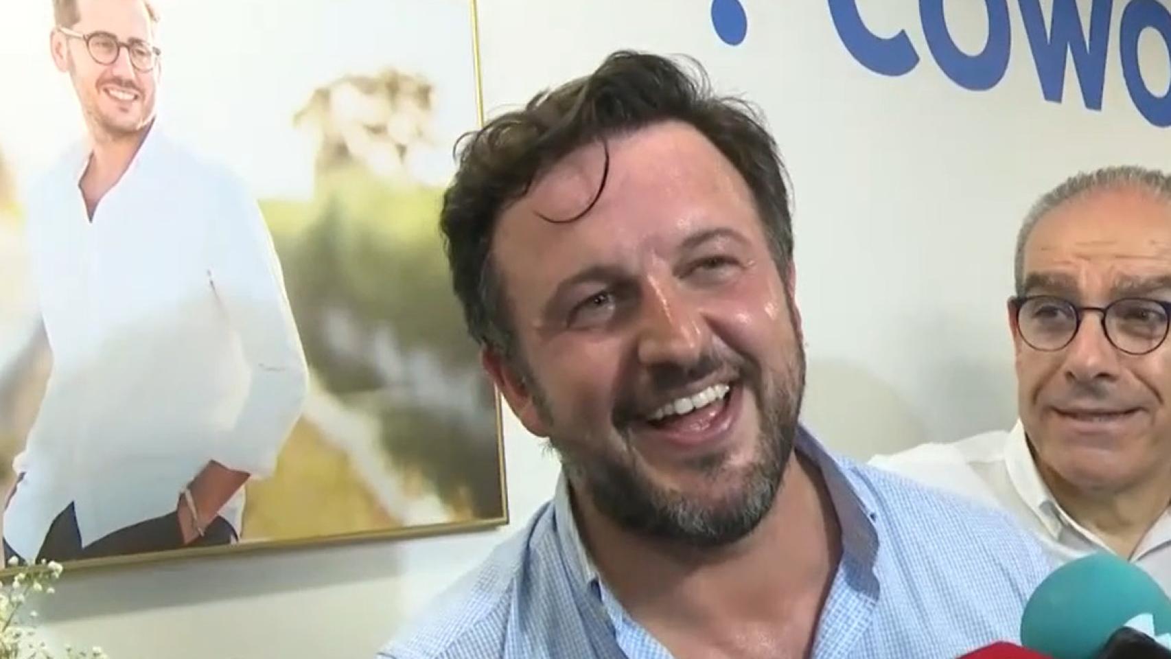Ruz atiende a los medios en la noche electoral con el retrato de Sergio Rodríguez detrás, en la sede de la agrupación.