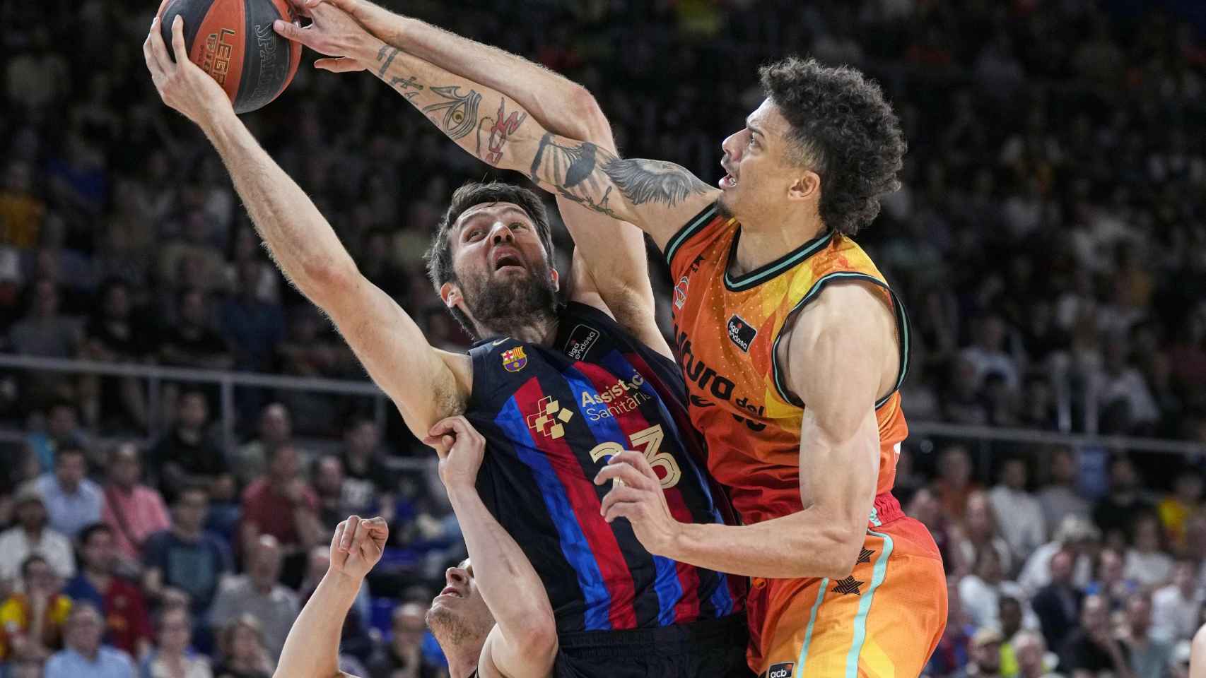El pivot del Barça, Michael Tobey, pelea un rebote ante el base de Valencia Basket, Jonah Radebaugh.
