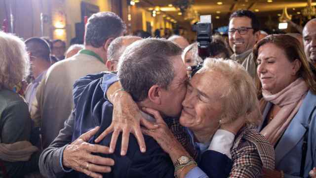 Emiliano García-Page abraza a una persona en la noche electoral