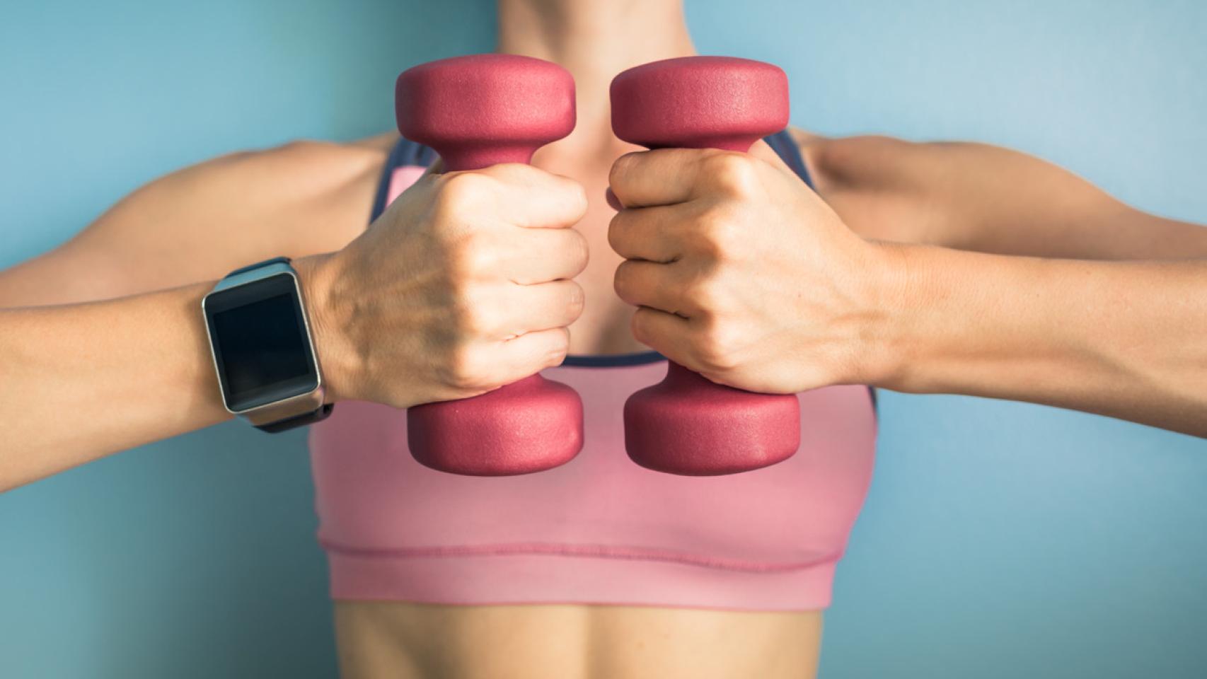 Mujer sosteniendo pesas. Foto: iStock.