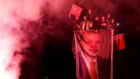 Un grupo de hombres despliega una bandera con la cara de Erdogan, este domingo en Ankara.