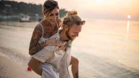 Una pareja con tatuajes en la playa.