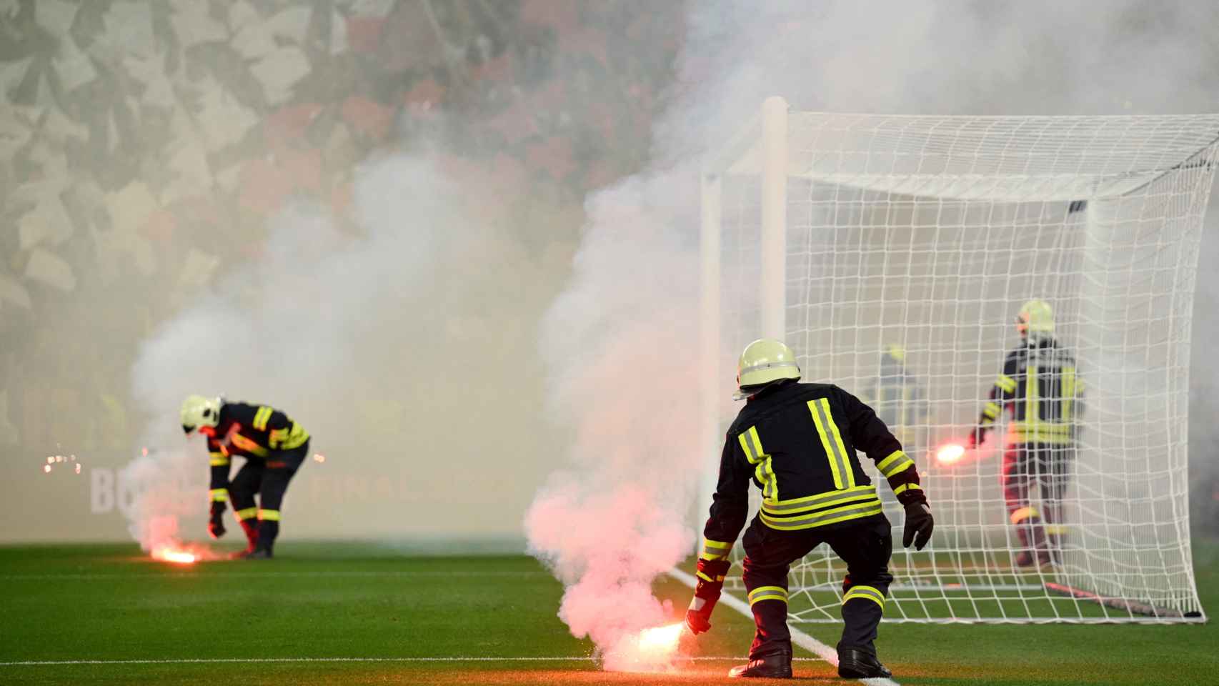 Los bomberos, quitando bengalas del campo en la final de la Europa League