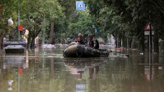 Dos militares ayudan a una persona tras las inundaciones en Emilia Romagna, en Italia.
