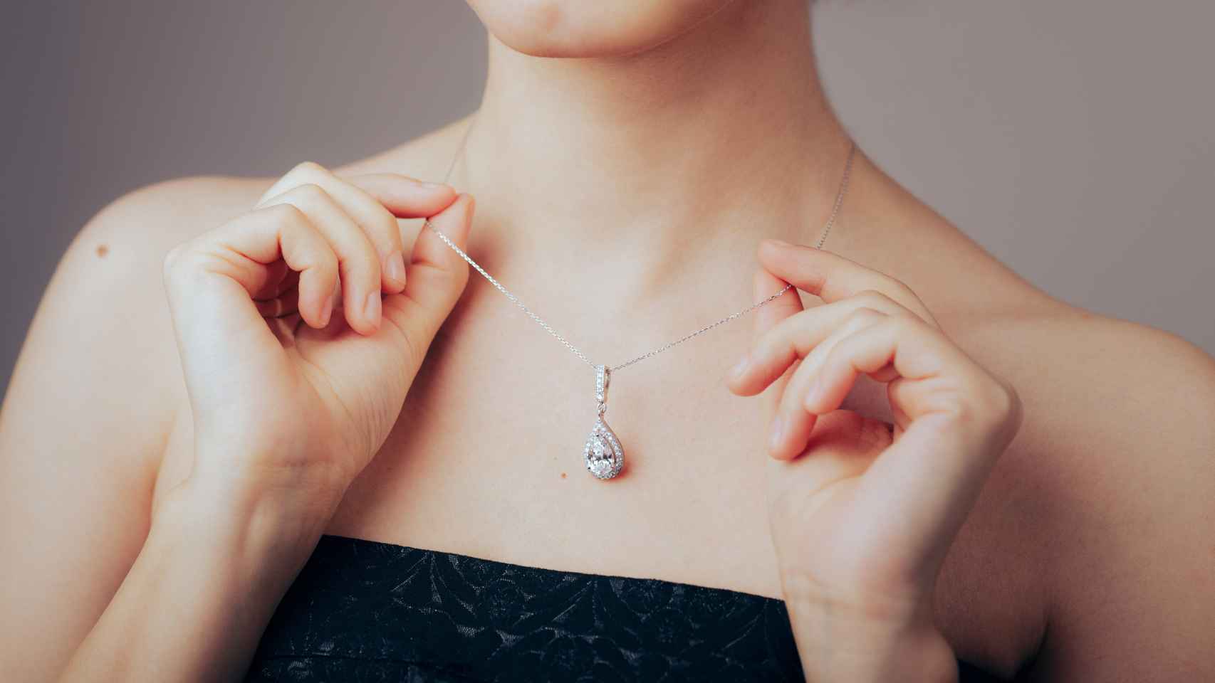 Una mujer se coloca un collar de diamantes.