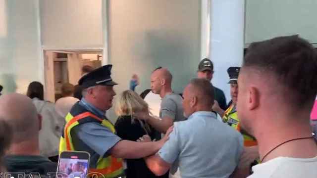 El árbitro Anthony Taylor, protegido por la policía en el aeropuerto.