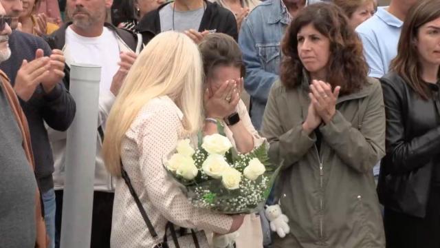 Allegados de Ana Vanessa Serén se derrumban junto a la alcaldesa de Oia, Cristina Correa (cd; aplaudiendo), durante el minuto de silencio celebrado en el camping O Muíño