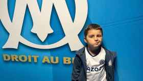Kenzo, el niño agredido, posando con la camiseta del Olympique de Marsella.