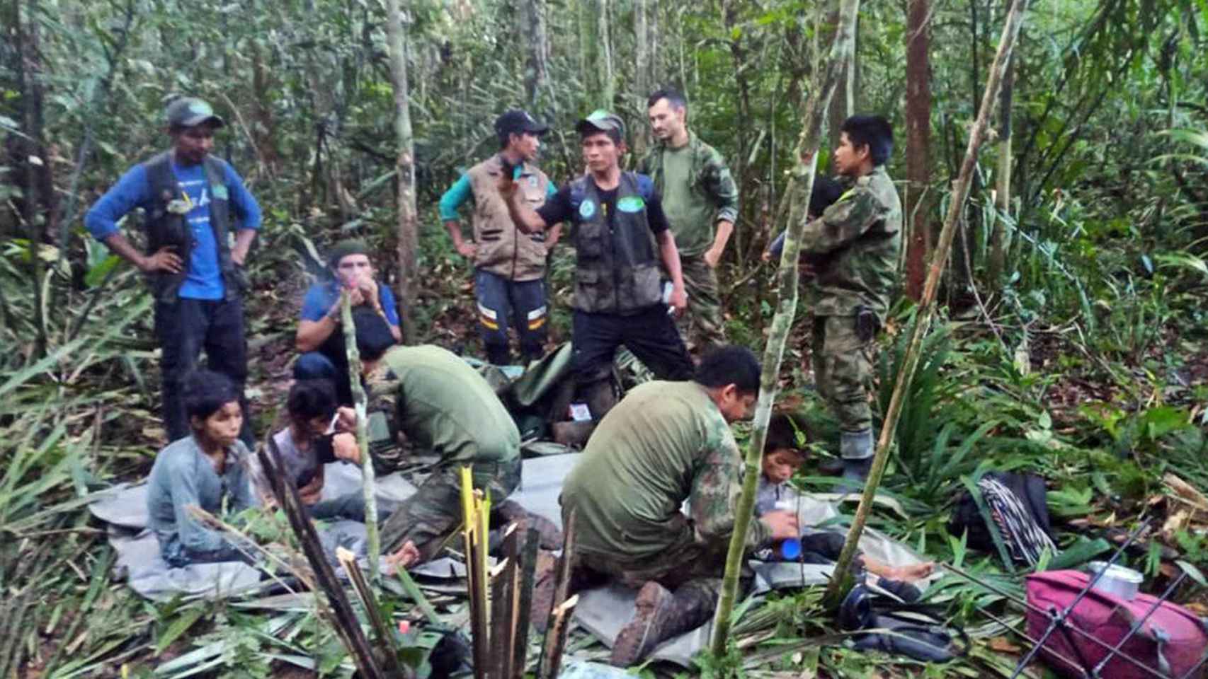 Militares del equipo de rescate dan de comer a los niños rescatados en la selva.