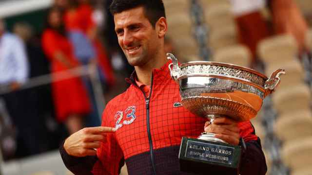 Novak Djokovic, señalándose el 23 y sujetando la Copa de los Mosqueteros tras ganar Roland Garros 2023