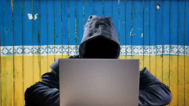 Fotomontaje con un hacker tras un mural con la bandera de Ucrania