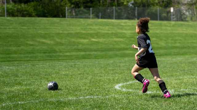 Una niña jugando al fútbol.
